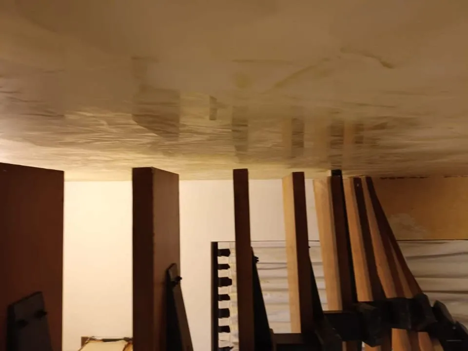 Detailaufnahme einer ockerfarbenen Spachteloberfläche im Streiflicht mit sichtbarer Wolkenstruktur